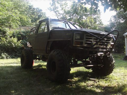 1986 Ford Bronco - This heavily modified Ford Bronco features an external roll cage and oversized off-road tires.