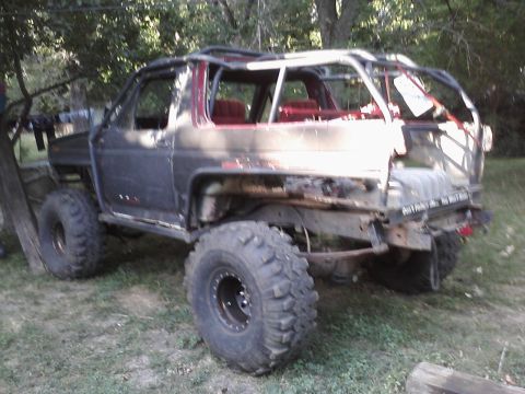 1986 Ford Bronco - This heavily modified 1986 Ford Bronco features a custom roll cage and oversized off-road tires, suggesting it's built for extreme terrain.
