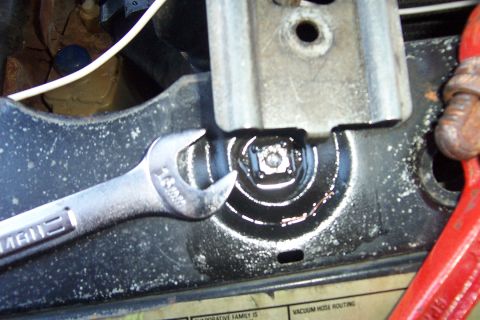 1980 Ford Bronco - Close-up under the hood of a chrome Craftsman open-end wrench set on a hex bolt head at a bracket mounting point on a black radiator suppor…