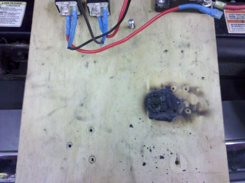 1995 Ford Bronco - Close-up of a damaged electrical component and wiring on a wooden surface.