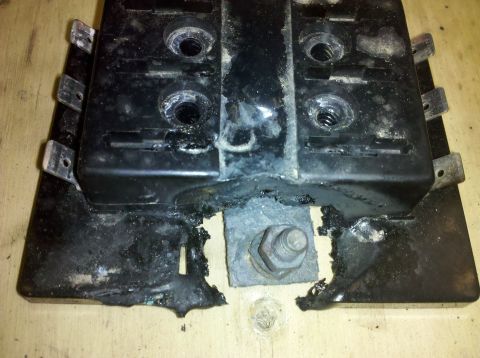 1995 Ford Bronco - A close-up view of a damaged battery terminal connector, showing signs of corrosion and melting.
