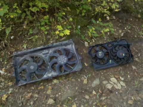 1995 Ford Bronco - Two car radiator fan assemblies are shown on the ground outdoors.