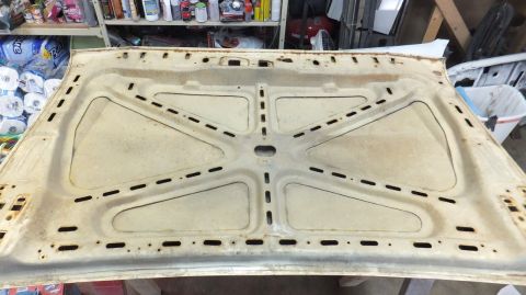 1983 Ford Bronco - The underside of a car hood is shown, with visible reinforcement structures and stamped openings.