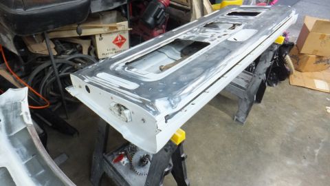 1983 Ford Bronco - A vehicle tailgate is shown on sawhorses in a workshop setting, undergoing preparation.