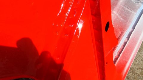 1983 Ford Bronco - Interior view of a red car door, showing paint and construction details.