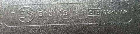 1993 Ford Bronco - Close-up of embossed text and numbers on a dark, textured surface, possibly a part identifier.