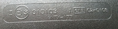Embossed text on a dark surface: E13 010103 1 613 0240103 GNTX-177