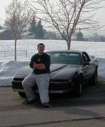 1991 Ford Bronco - A man poses with a black coupe pop-up headlights in a snowy outdoor setting.