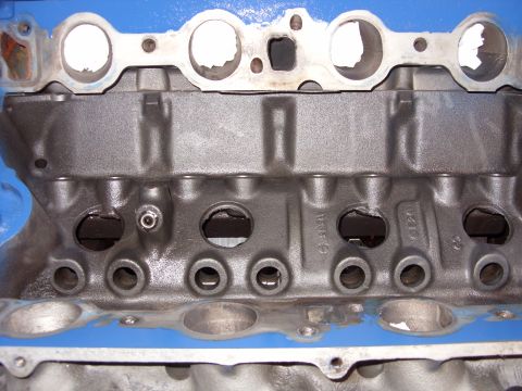 1967 Ford F-250 - Engine block detail showing intake ports and bolt holes, part of a larger automotive engine assembly.
