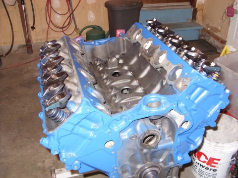1967 Ford F-250 - A blue painted engine block with rocker arms and springs is shown in a workshop setting.