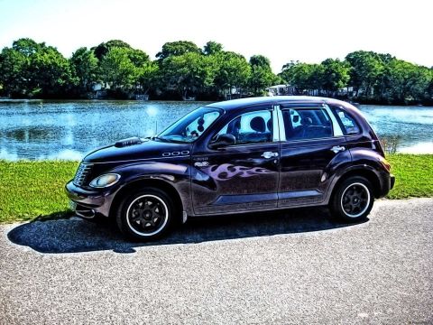 2005 Chrysler PT Cruiser - A purple Chrysler PT Cruiser with flame decals sits parked next to a body of water on a sunny day.