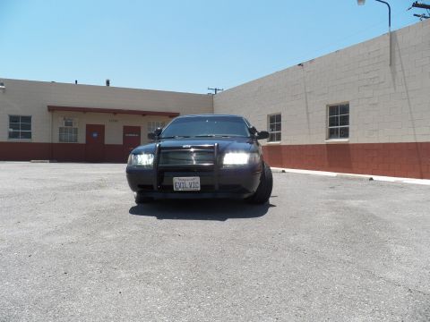 2003 Ford Crown Victoria - Front view of a blacked-out Crown Victoria with a push bar; California plate reads EVIL VIC.