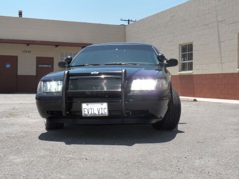 2003 Ford Crown Victoria - Close front view of a black Crown Victoria; brush guard frames the EVIL VIC plate.