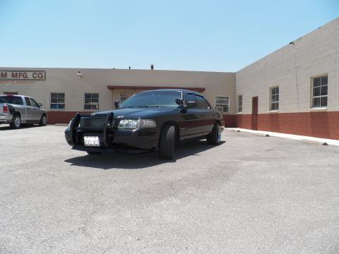 2003 Ford Crown Victoria - Three-quarter front of a black Crown Victoria with brush guard at an industrial lot.