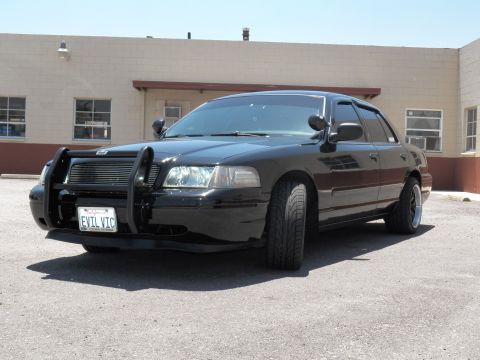 2003 Ford Crown Victoria - Front-quarter view of a lowered black Crown Victoria wearing a push bar and EVIL VIC plate.