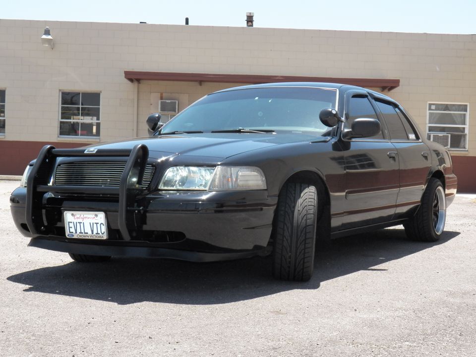 Black Crown Victoria front quarter close-up with push bar, dark wheels and EVIL VIC California plate