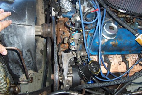 1980 Ford Bronco - Close-up view of an engine bay, showing blue valve covers, belts, and pulleys.