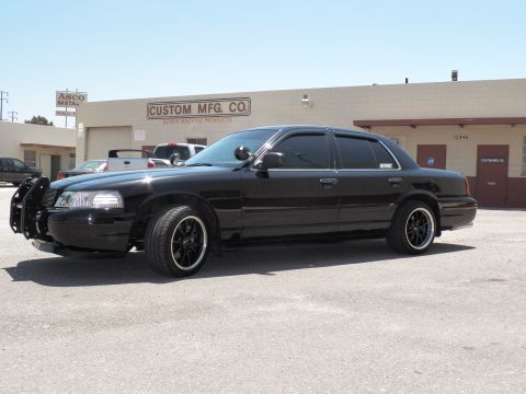 2003 Ford Crown Victoria - Front-quarter of a lowered black Crown Victoria with brush guard at an industrial lot.