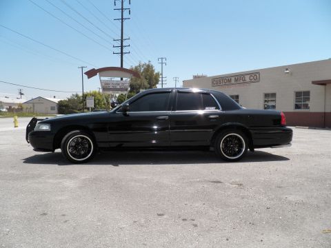 2003 Ford Crown Victoria - Side profile of a lowered black Crown Victoria on machined-lip wheels by a warehouse.