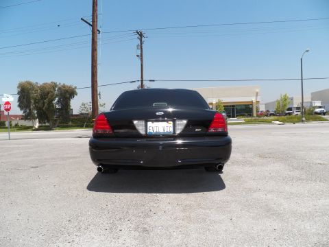 2003 Ford Crown Victoria - Centered rear shot of a black Crown Victoria sedan with EVIL VIC plate, SVT badge and twin exhaust outlets.