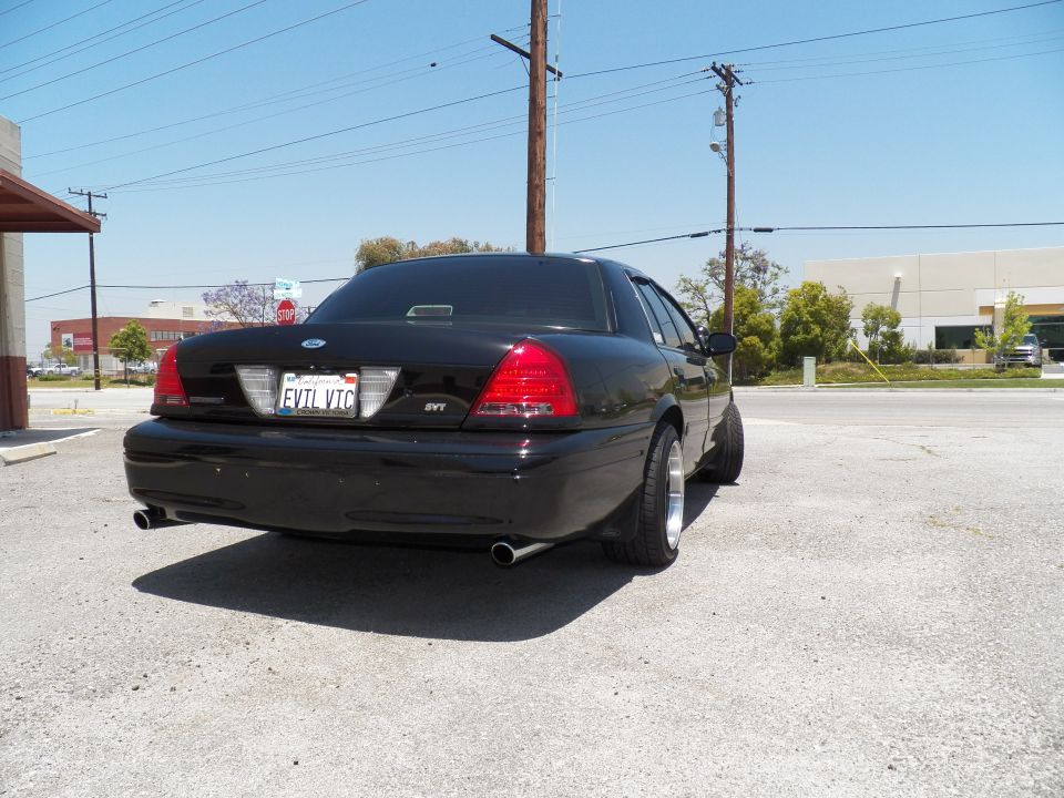 Black Ford Crown Victoria rear three-quarter view with EVIL VIC plate and aftermarket wheels