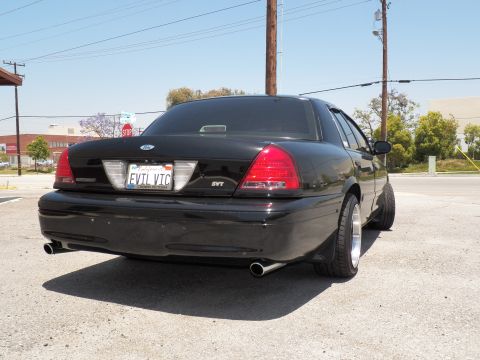 2003 Ford Crown Victoria - Lowered black Crown Victoria viewed from rear left; SVT trunk badge and EVIL VIC plate visible.