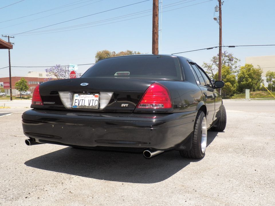 Black Ford Crown Victoria rear three-quarter with dual exhaust and EVIL VIC California plate