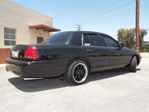 2003 Ford Crown Victoria - Right rear three-quarter of a lowered black Crown Victoria with black multi-spoke wheels.