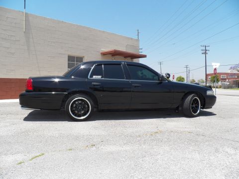 2003 Ford Crown Victoria - Side profile of a lowered black Crown Victoria sedan with tinted windows and black wheels.