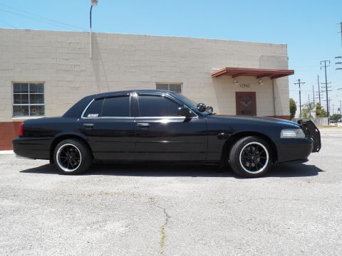 2003 Ford Crown Victoria - Lowered black Crown Victoria sedan shown in left-side profile beside a concrete building.