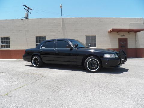 2003 Ford Crown Victoria - Lowered black Crown Victoria from the right front showing brush guard and black multi-spoke wheels.