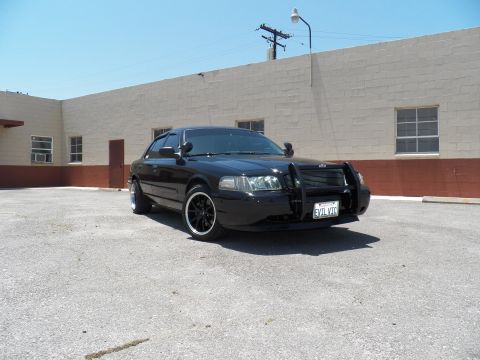 2003 Ford Crown Victoria - Front right three-quarter of a black Crown Victoria with brush guard and EVIL VIC plate.