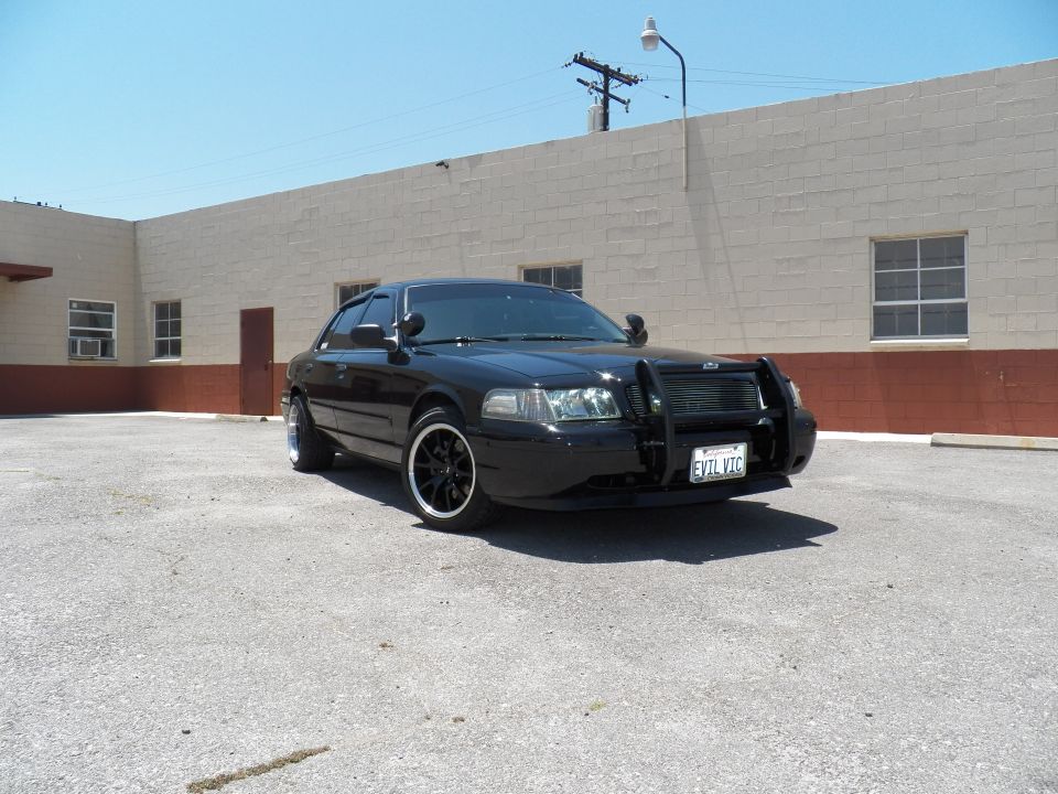 Black Ford Crown Victoria front three-quarter with brush guard and EVIL VIC California plate