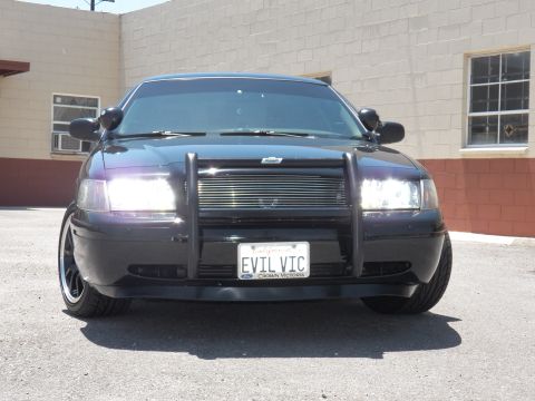 2003 Ford Crown Victoria - Centered front shot of a black Crown Victoria with brush guard, billet grille and EVIL VIC California plate.