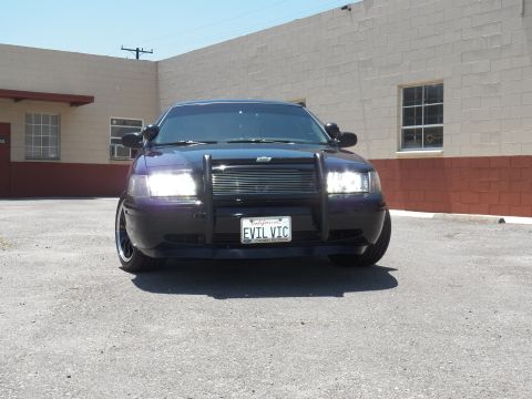 2003 Ford Crown Victoria - Close front-on view of a blacked-out Crown Victoria sedan with chrome billet grille insert in a lot.