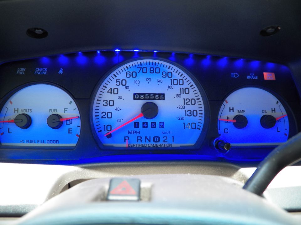 Vehicle gauge cluster with blue LED backlight, odometer reads 085565 miles, 140 mph speedo