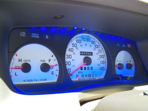 2003 Ford Crown Victoria - Angled view of blue-backlit white-faced gauges, fuel door arrow and PRNDL indicator on the cluster.
