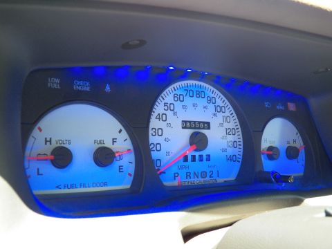 2003 Ford Crown Victoria - Instrument cluster with intense blue glow, speedometer centered between fuel and temperature gauges.