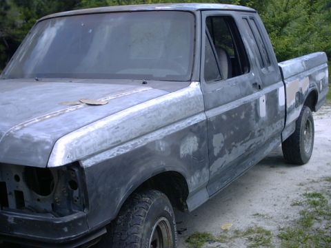 1989 Ford F-150 - This Ford F-150 truck is in the process of body work, with primer and filler visible on its exterior.