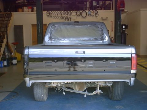 1989 Ford F-150 - The rear of a 1989 Ford F-150 pickup truck is shown, with the word FORD clearly visible on the tailgate.
