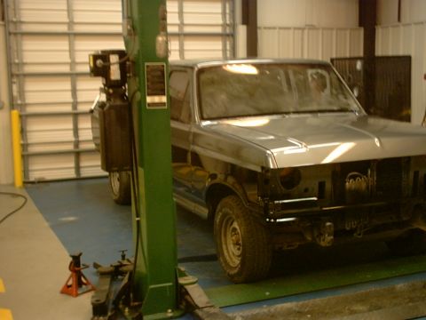 1989 Ford F-150 - Silver pickup truck in a garage with its front end disassembled and raised on a lift.