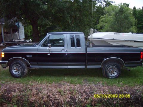 1989 Ford F-150 - This 1989 Ford F-150 pickup truck is shown in a side profile with a boat loaded in its bed.