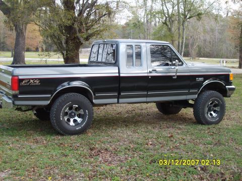 1989 Ford F-150 - Side view of a lifted 1989 Ford F-150 FX4 Off Road pickup truck with two-tone paint.