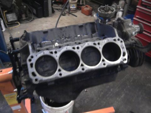 1989 Ford F-150 - Close-up of an engine block with pistons visible inside the cylinders, set up in a workshop.