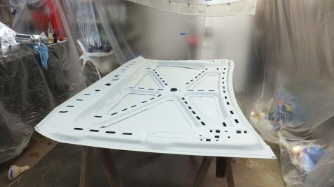 1983 Ford Bronco - The underside of a white car hood is shown, possibly being prepped for painting or restoration.