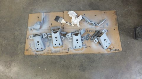1983 Ford Bronco - Door hinges painted and drying on cardboard.