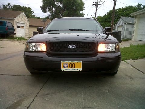 1999 Ford Crown Victoria - Front view of a black Ford Crown Victoria parked on a concrete driveway.