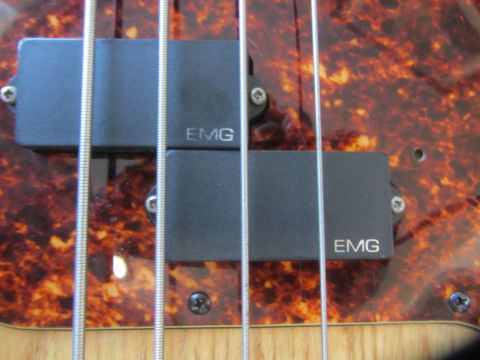 1968 Ford Mustang - Close-up of EMG pickups and strings on a bass guitar's pickguard.