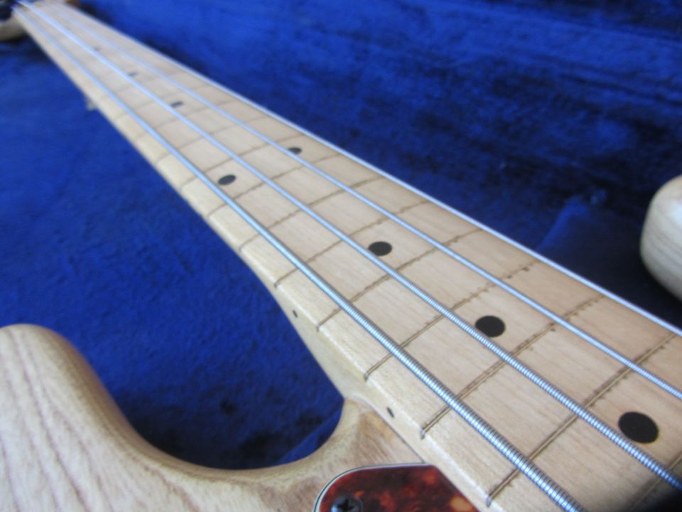 Close-up of a bass guitar neck with frets and strings