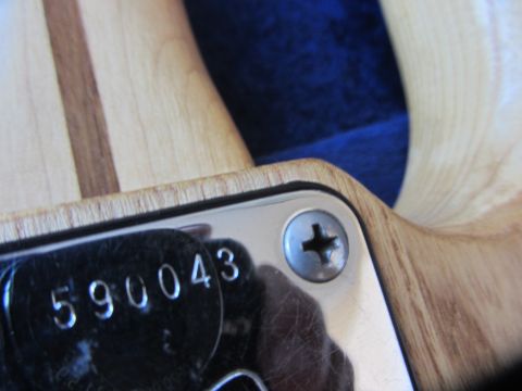 1968 Ford Mustang - A close-up view of the serial number plate, reading 590043, on a wooden instrument.